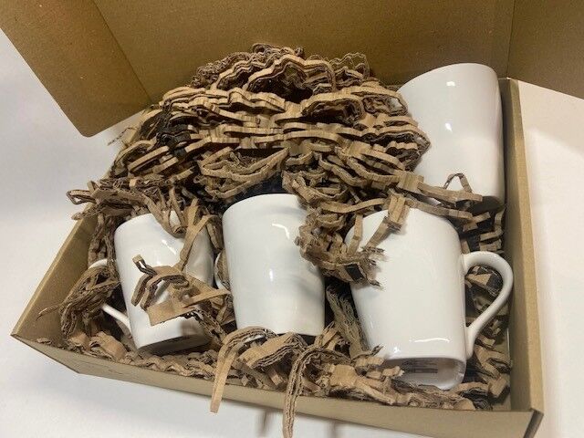 Mugs en porcelaine calés dans du carton de rembourrage